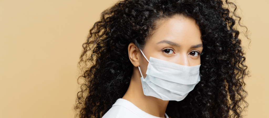 Woman wearing surgical mask protecting herself and others from COVID-19.