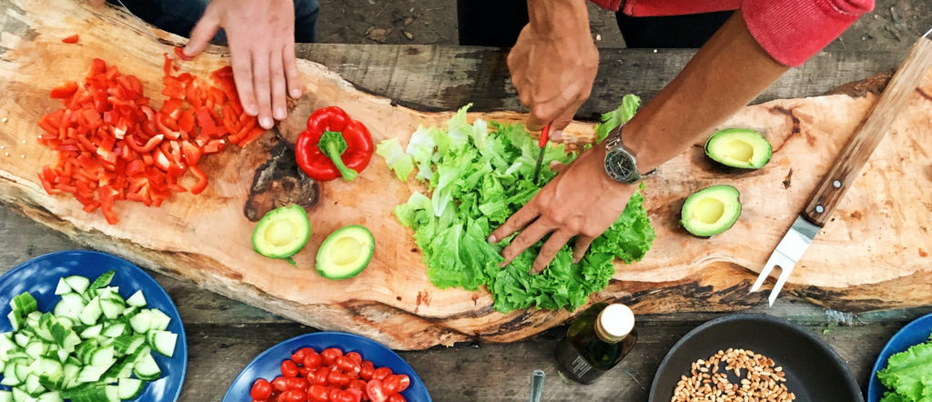 two people cut vegetables