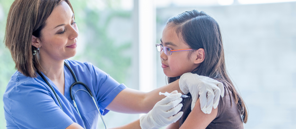 Female nurse practitioner administering a vaccines to a child as part of routine immunizations.